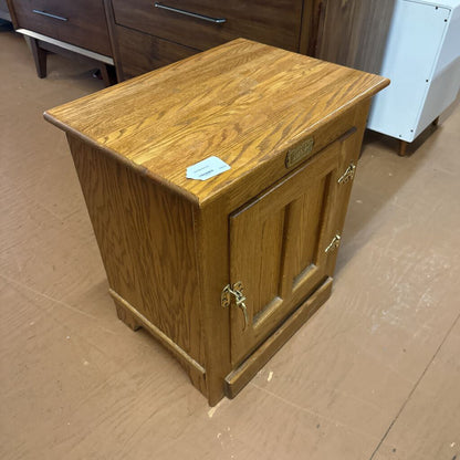 Wooden cabinet with a small door on a brown floor