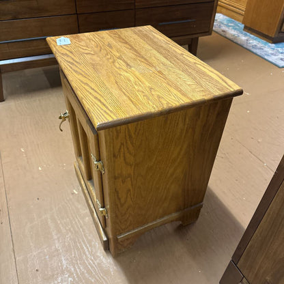 Wooden side table on a wooden floor with other furniture in the background