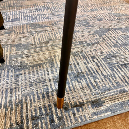 Cane tip on a patterned blue and beige rug