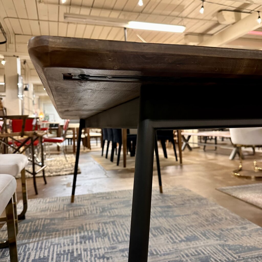 Dining table with black legs in a showroom setting