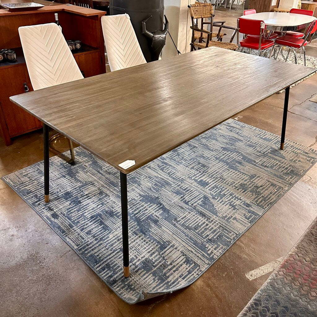 Long wooden table on a patterned rug in an indoor setting