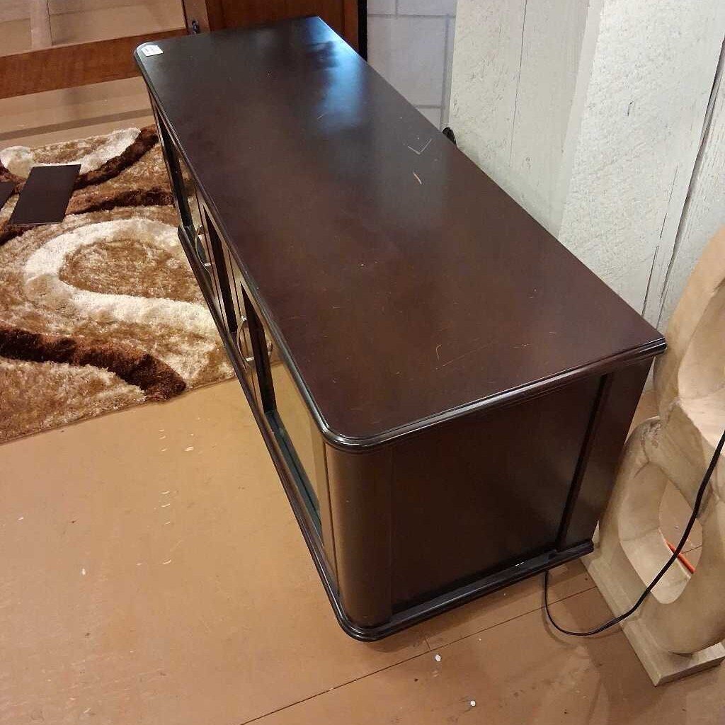 Brown wooden desk in a room with a carpeted floor and wall.