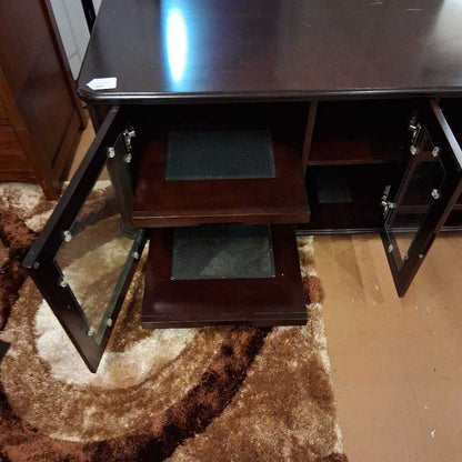 Wooden desk with glass top on a brown carpet