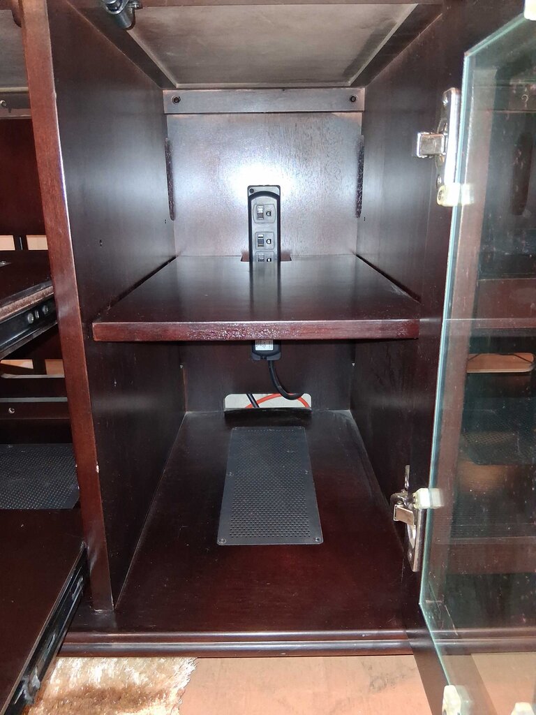 Wooden cabinet with a power outlet on a wooden floor