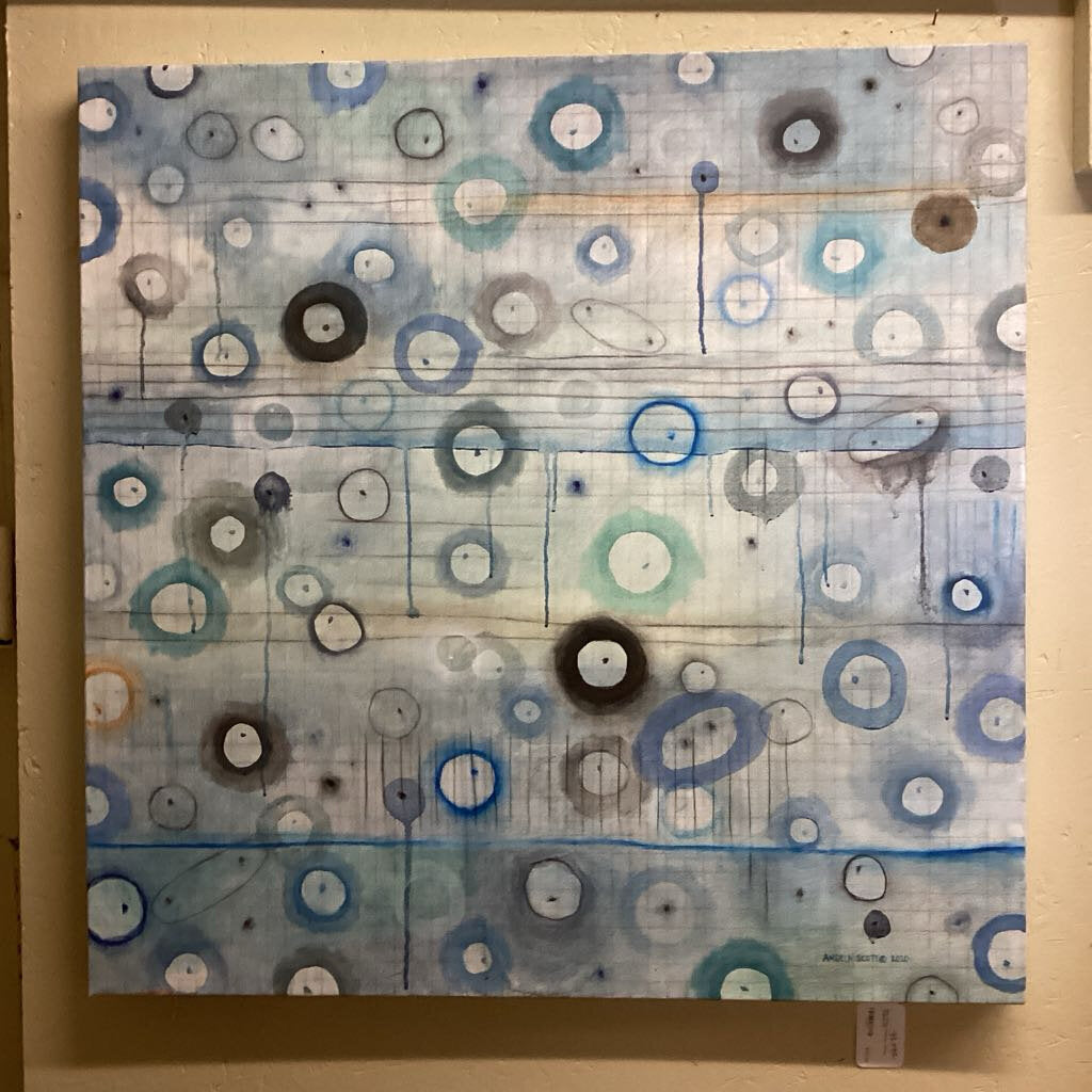 Abstract artwork with circular patterns on a wooden panel