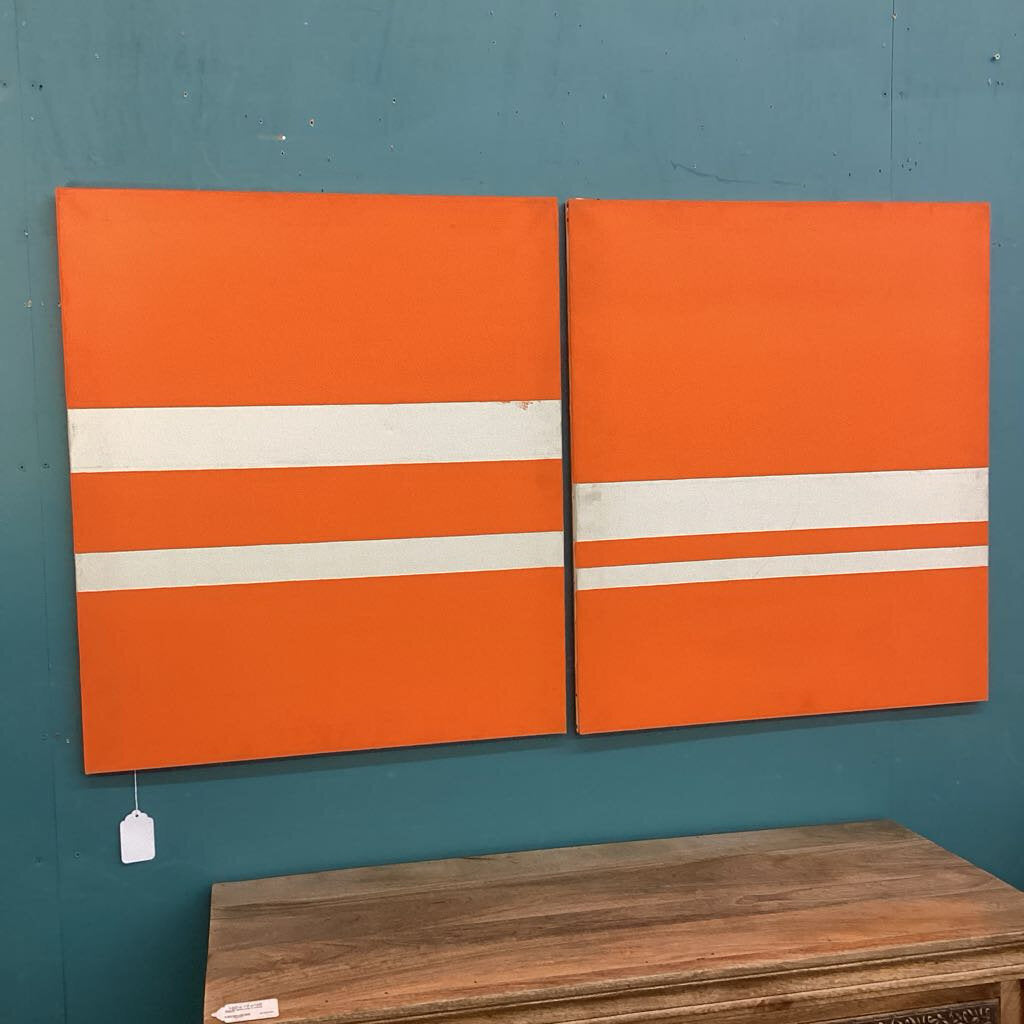 Two orange panels with white stripes on a teal wall.
