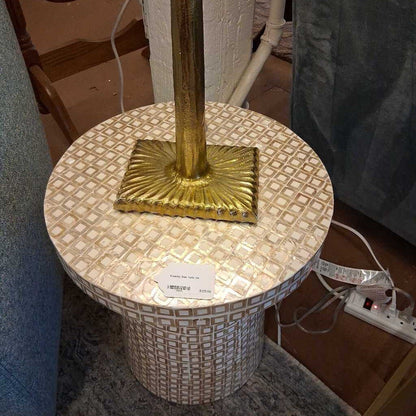 Decorative table with gold base and patterned top in a room setting