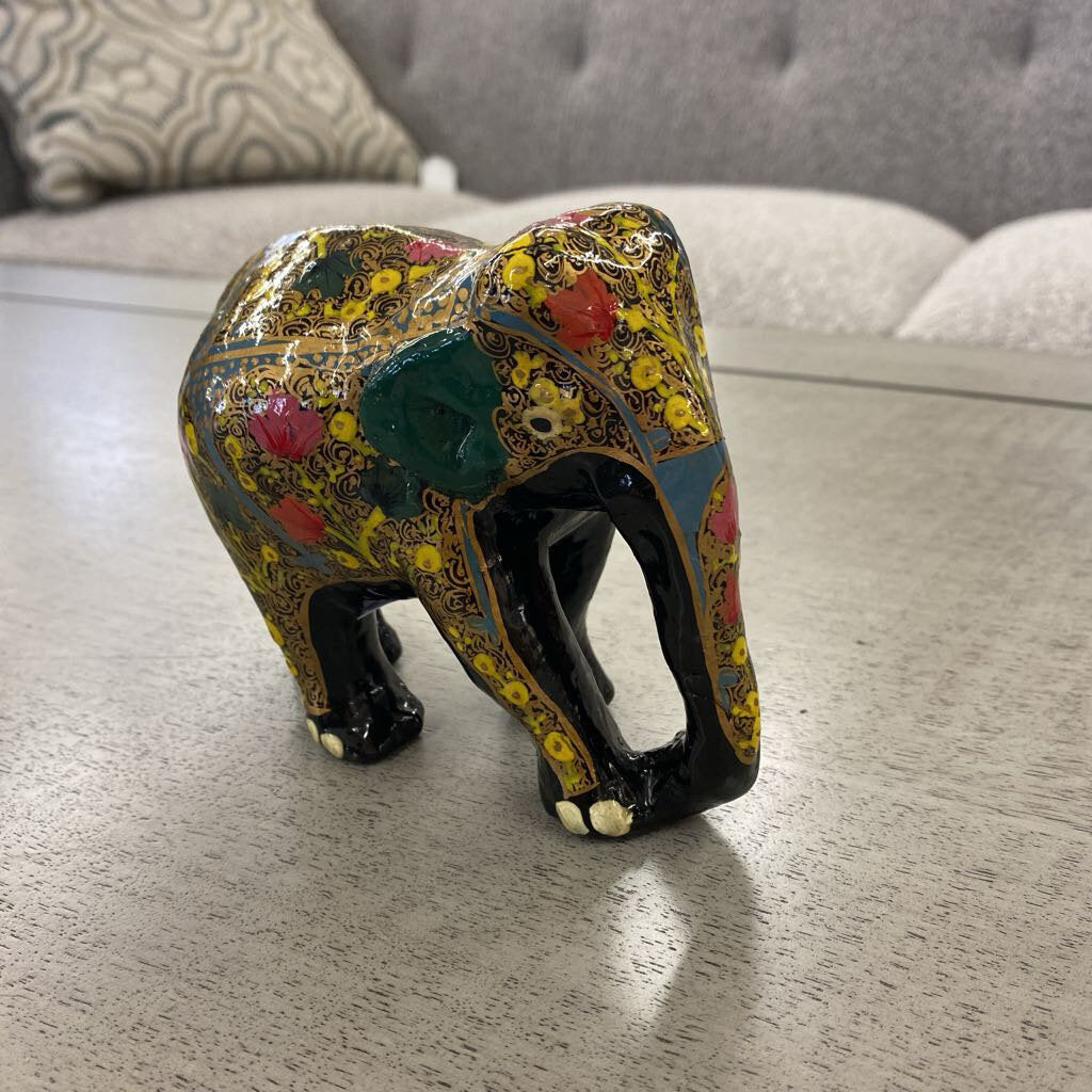 Decorative elephant figurine on a wooden surface with a blurred background
