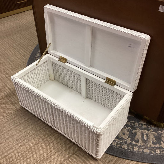 White wicker storage chest on a carpeted floor