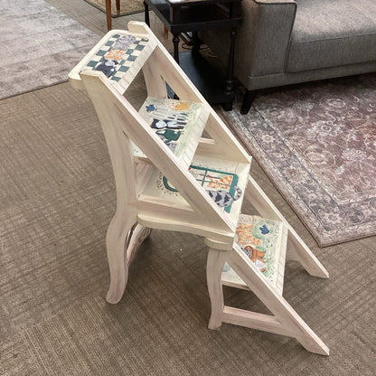 White step stool with patterned top in a living room setting