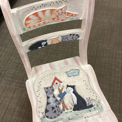 Chair with cat-themed cushion and backrest on a carpeted floor