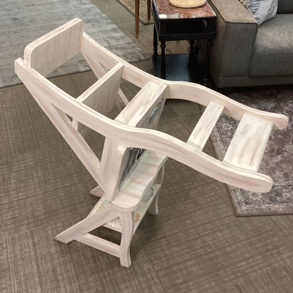 White wooden step stool on a carpeted floor with a living room background