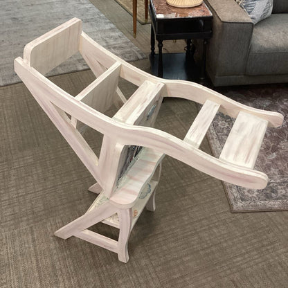 White wooden step stool on a carpeted floor with a living room background