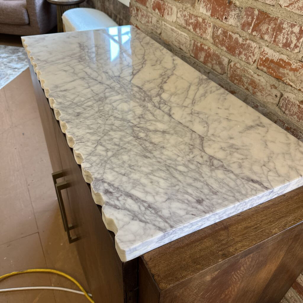Marble countertop on a wooden cabinet with a brick wall background