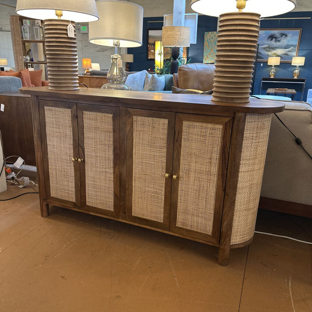 Wooden sideboard with wicker doors in a showroom setting