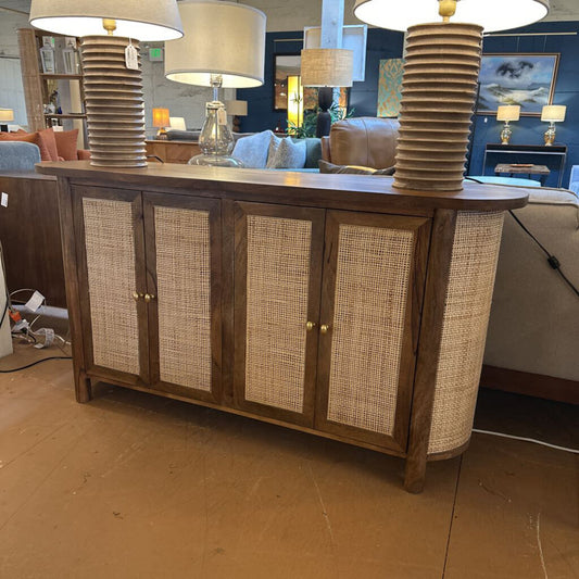 Wooden sideboard with wicker doors in a showroom setting