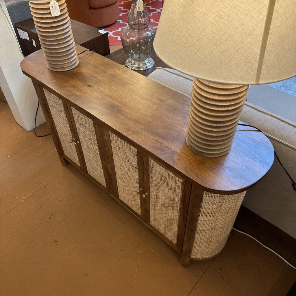 Wooden console table with a lamp and decorative items in a room setting