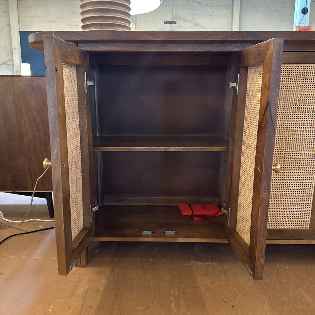 Wooden cabinet with open doors revealing shelves and a red item on a wooden floor.
