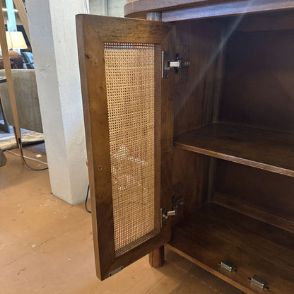 Wooden cabinet with wicker door in a room setting