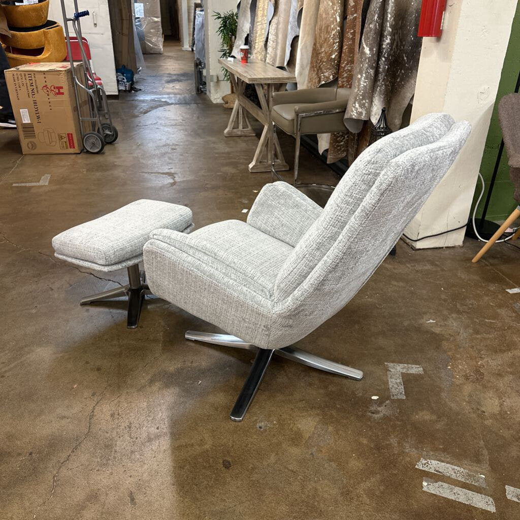 Gray swivel chair with ottoman in a warehouse setting