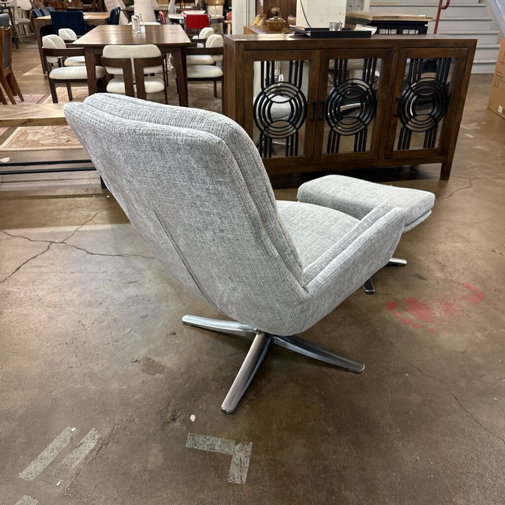 Gray swivel chair in a room with tables and chairs in the background