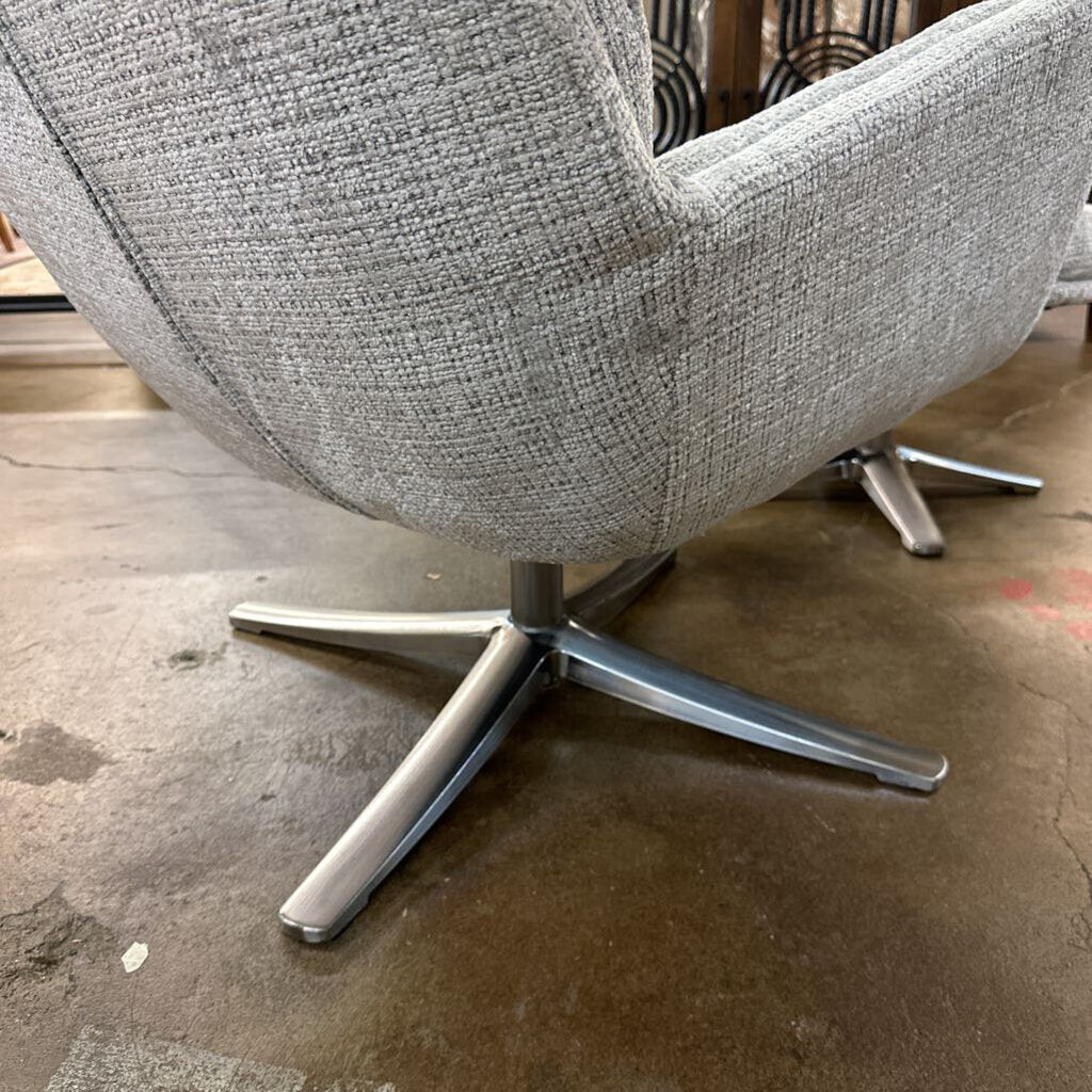 Gray textured armchair with a metal base on a concrete floor.
