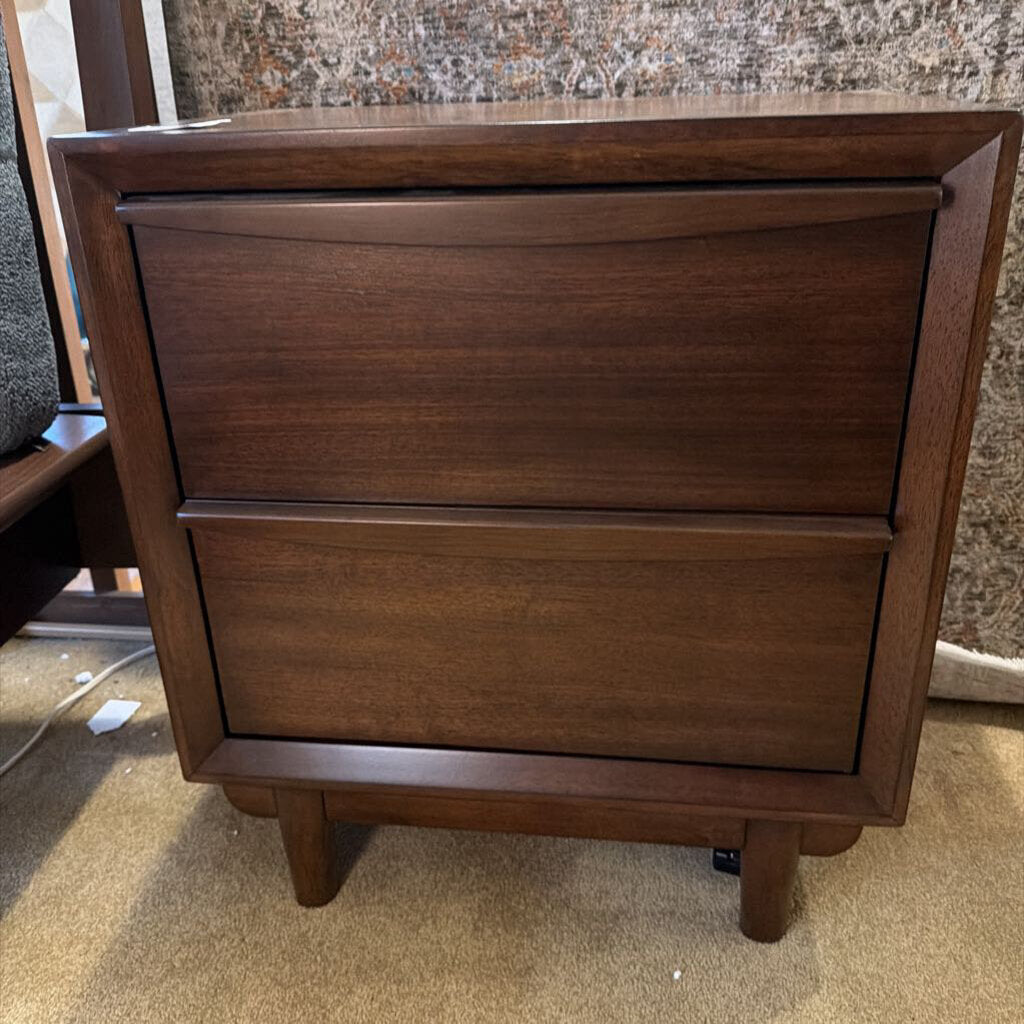 Wooden dresser with two drawers on a carpeted floor.