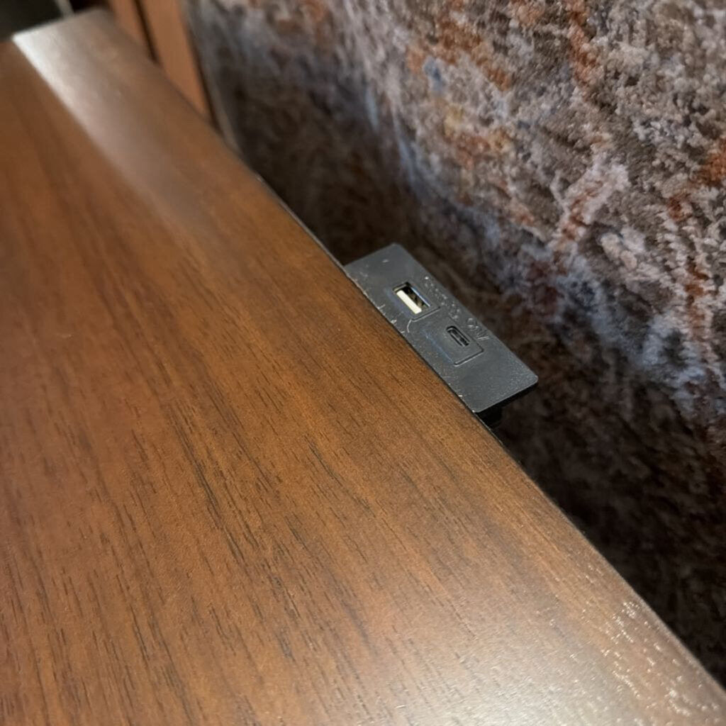 Wooden surface with a built-in electrical outlet.