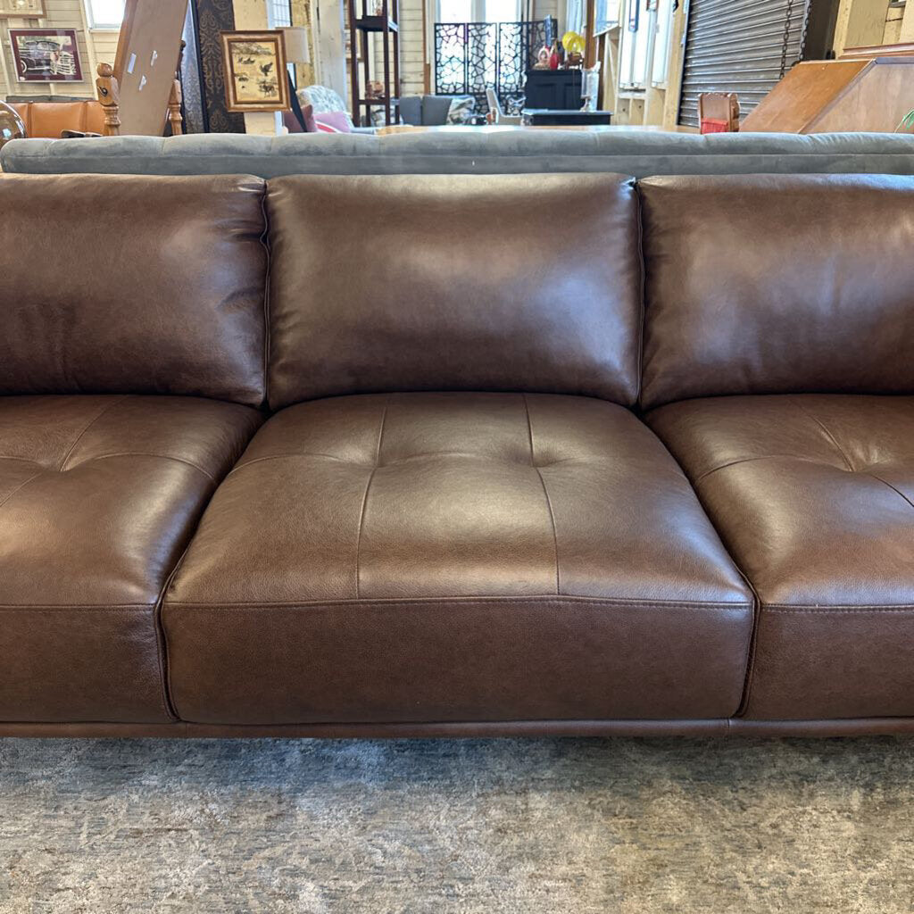 Brown leather sectional sofa in a showroom setting