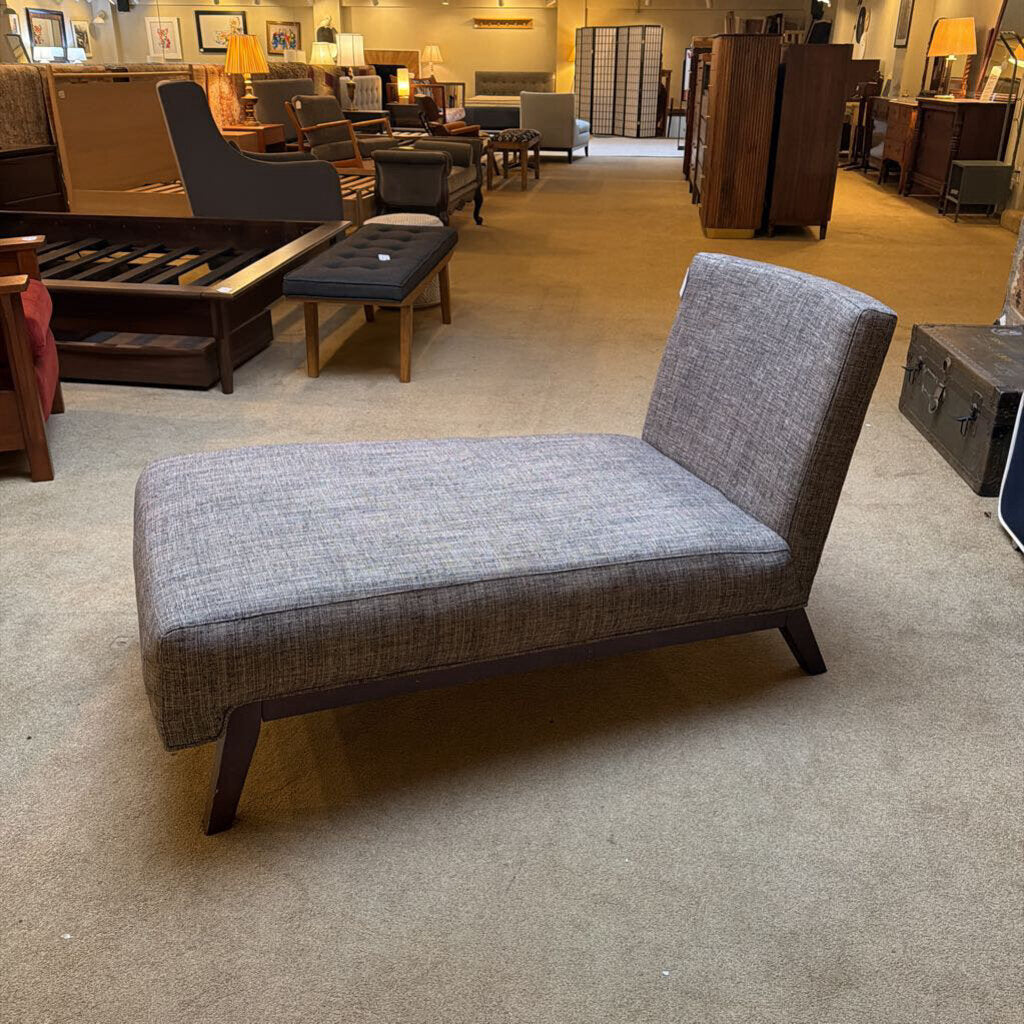 Gray upholstered bench in a furniture store setting