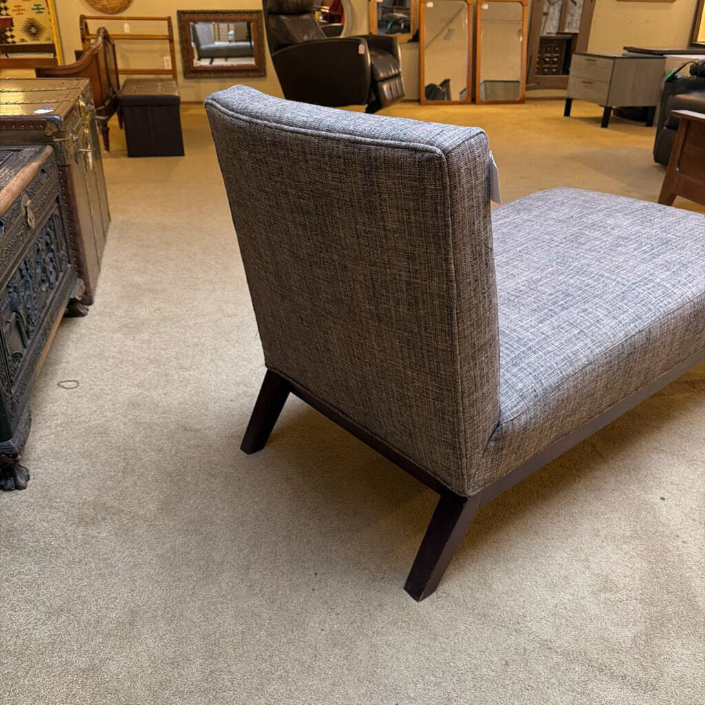 Gray upholstered chair with wooden legs in a showroom setting