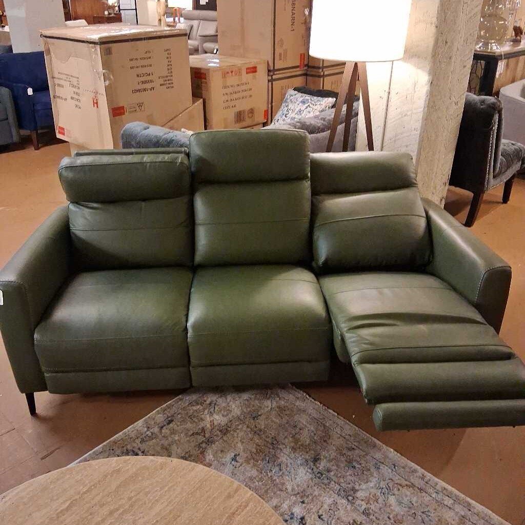 Green sectional sofa in a room with boxes and furniture.