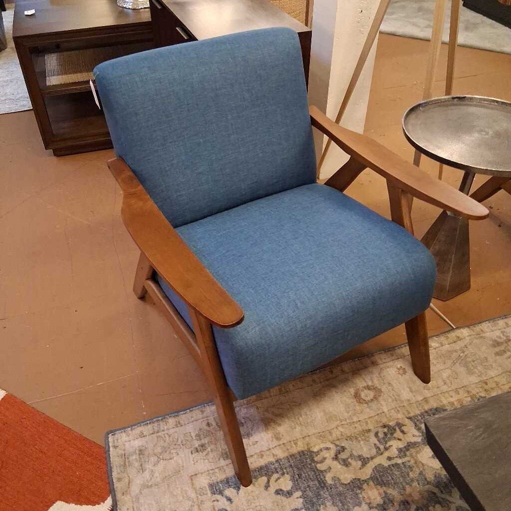 Blue armchair with wooden arms and legs in a room setting