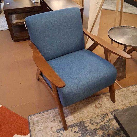 Blue armchair with wooden arms and legs in a room setting