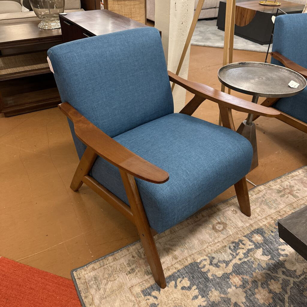 Blue armchair with wooden arms and legs in a room setting