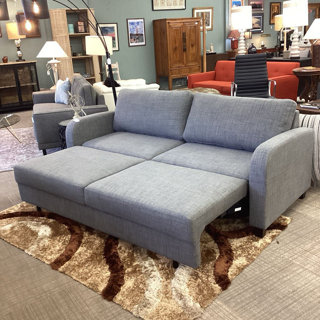 Gray sectional sofa in a living room setting with furniture and decor.