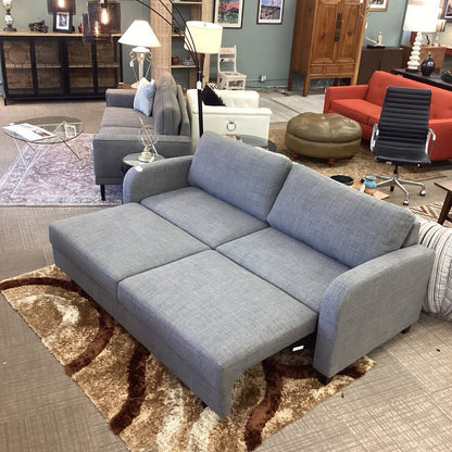 Gray sectional sofa in a living room setting with furniture and decor.