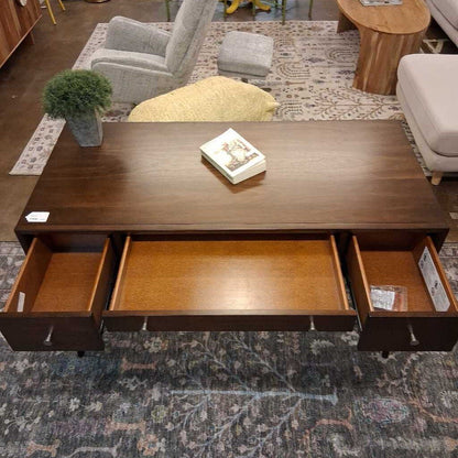 Wooden coffee table with open drawers in a living room setting
