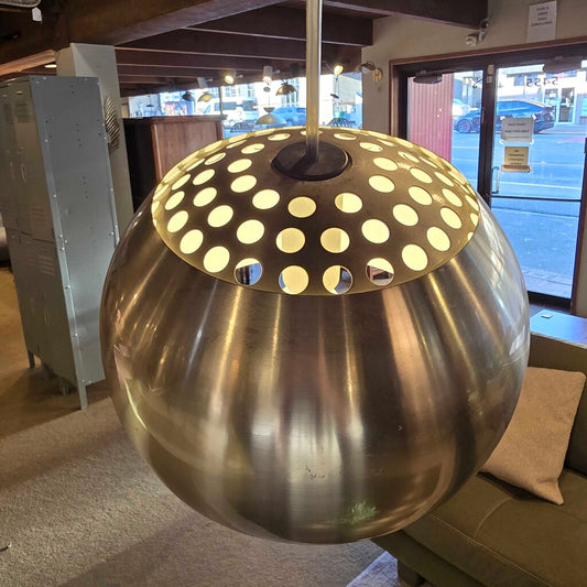 Decorative metal sphere with polka dot design on top, indoors.