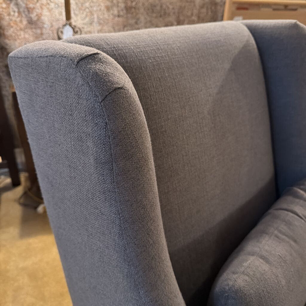 Gray upholstered chair with a blurred background