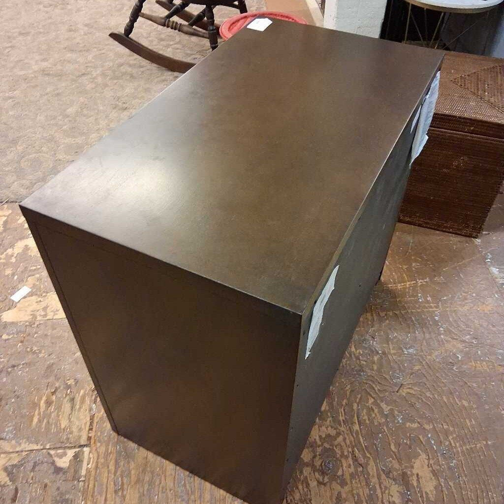 Metallic brown rectangular object on a wooden floor