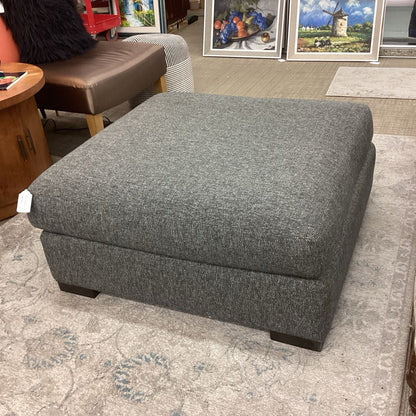 Gray ottoman in a room with furniture and decor