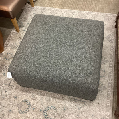 Gray ottoman on a patterned rug