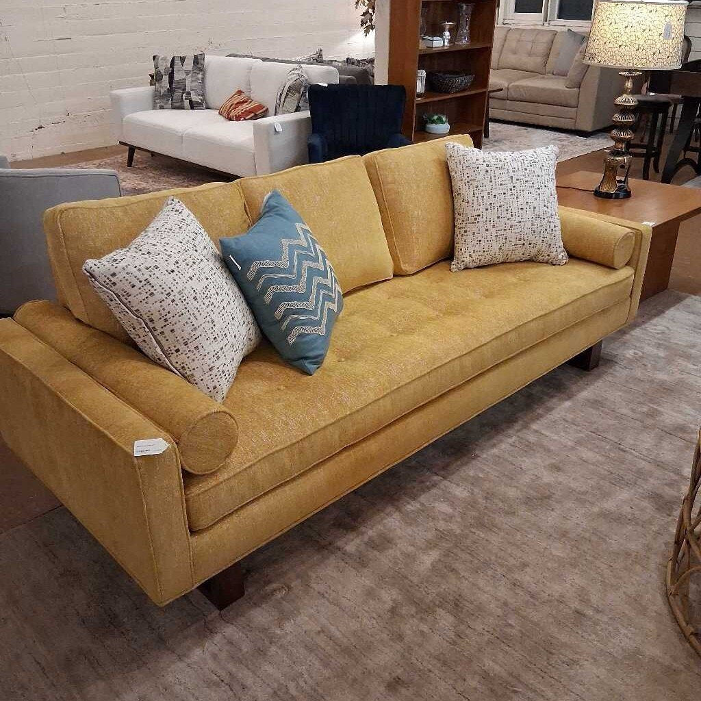 Yellow sofa with decorative pillows in a room setting