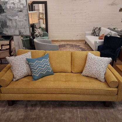 Yellow sofa with patterned cushions in a living room setting