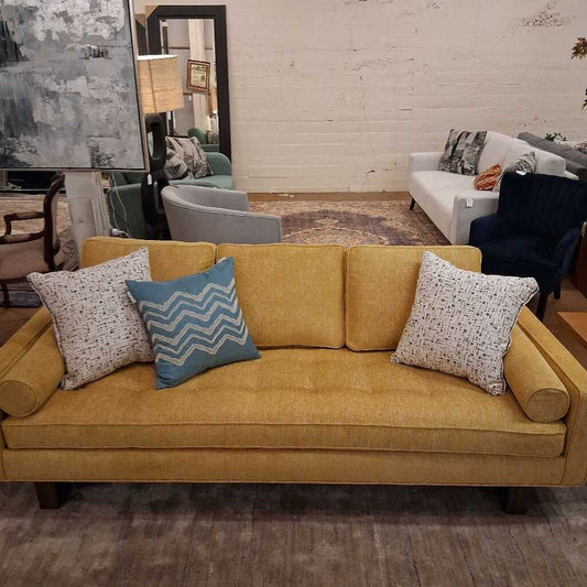 Yellow sofa with patterned cushions in a living room setting