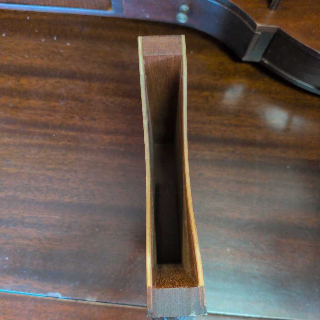Close-up of a wooden object with a slot on a wooden surface