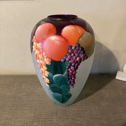Decorative vase with fruit design on a neutral background