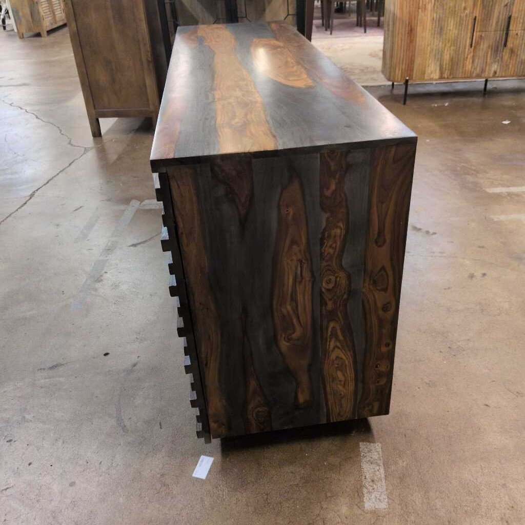 Wooden console table with a unique grain pattern on a concrete floor.