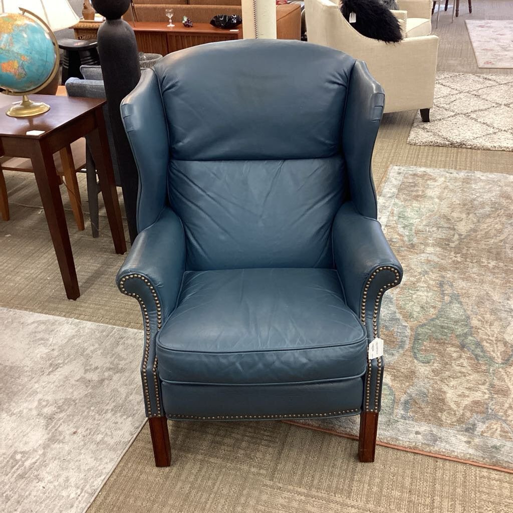 Blue leather armchair in a room with furniture and decor.